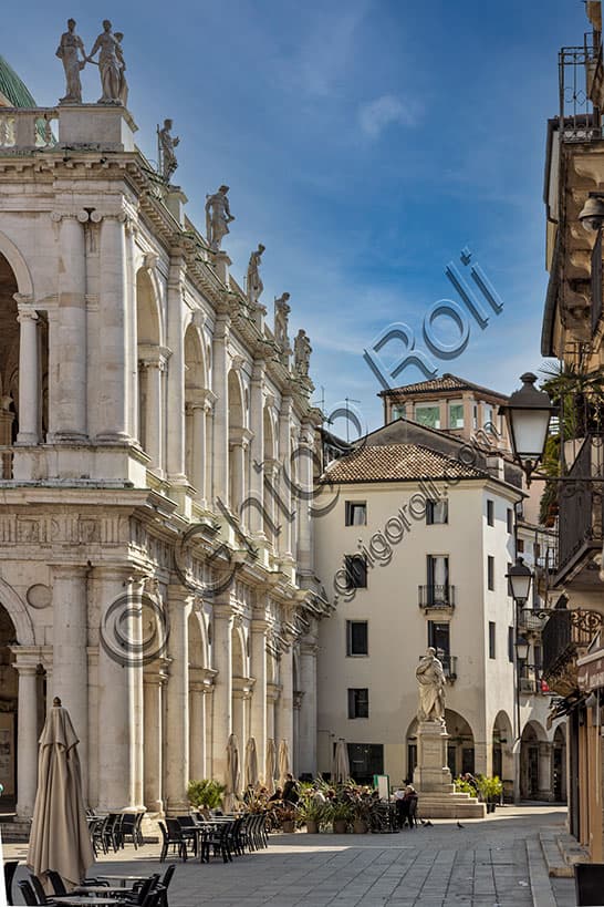 Statua di Andrea Palladio nella piazzetta con tavolini di bar e scorcio della Basilica Palladiana a Vicenza