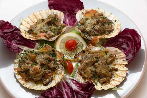 Piatto di capesante gratinate con funghi porcini, servite in una teglia da forno calda.