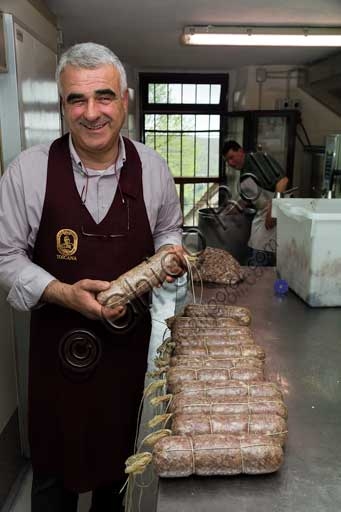 Luciano Porciatti mostra la finocchiona, tipico salume del Chianti, nella bottega Casa Porciatti a Radda in Chianti