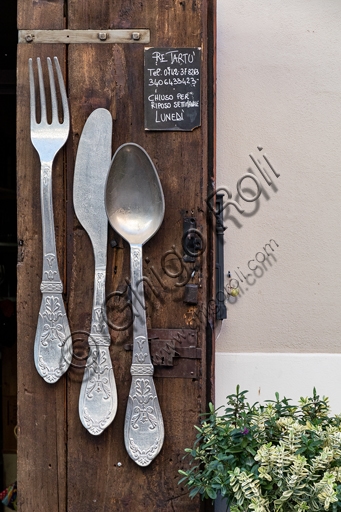 Wrought iron sign with cutlery of Re Tartù Restaurant in Montefalco, Umbria
