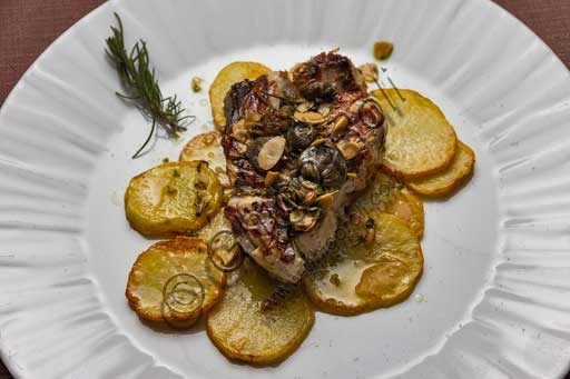 Dish of oven-baked amberjack with potatoes from La Rocchetta restaurant, Italian trattoria seafood