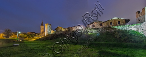 Illuminated night view of the ancient stone walls of the Candelo Ricetto fortified medieval village, Piedmont, Italy
