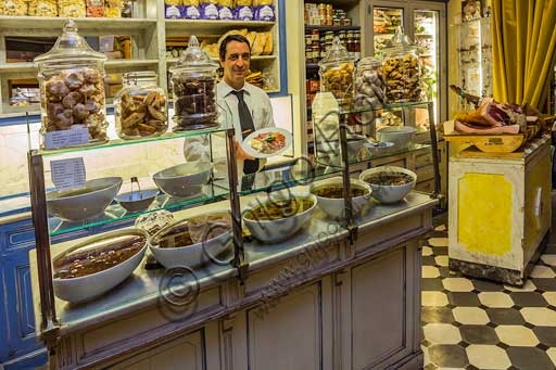 Interior of Olio & Convivium restaurant in Florence featuring an olive bar and display of typical Tuscan food products