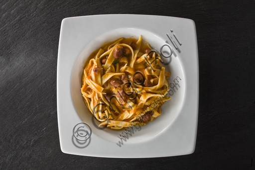 Plate of tagliatelle alla bolognese with traditional ragù, served on a wooden table.