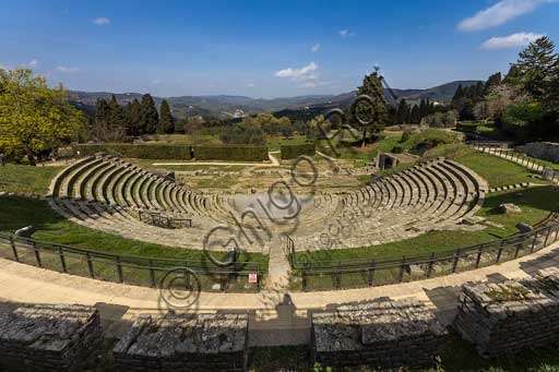 Veduta panoramica del Teatro Romano di Fiesole all'interno dell'Area Archeologica, con gradinate e scena sullo sfondo del paesaggio toscano.