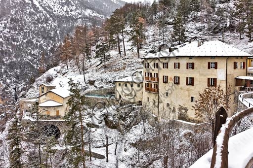 Veduta esterna degli antichi edifici in pietra delle Terme Bagni Vecchi a Bormio, immersi nel paesaggio alpino