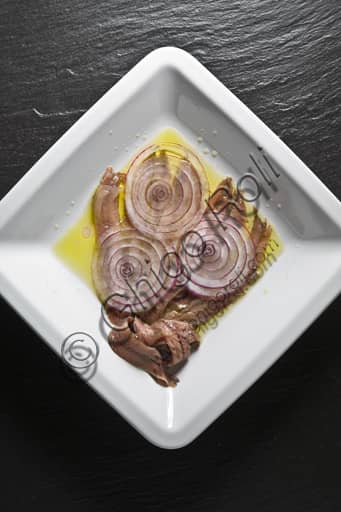 Piatto tradizionale di alici (acciughe) fresche con cipolle bianche affettate, preparazione rustica