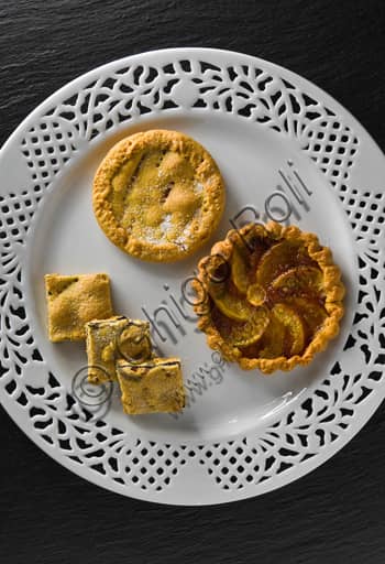 Piatto con piccole crostate di pasta sfoglia, dolci e salate, presentate come antipasto finger food