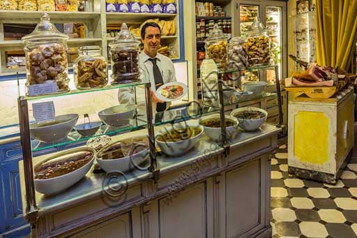 Interior of Olio & Convivium restaurant in Florence featuring an olive bar and display of typical Tuscan food products