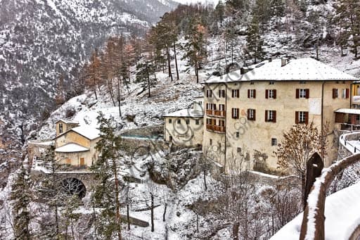 Veduta esterna degli antichi edifici in pietra delle Terme Bagni Vecchi a Bormio, immersi nel paesaggio alpino