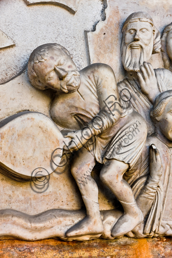 Dettaglio scultoreo del carnefice con mantice, lunetta del Martirio di San Lorenzo, portale Duomo di Genova (1225 c.)