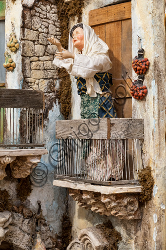 Dettaglio presepe siciliano di Ivano Vecchio: statuina in legno di donna affacciata al balcone, Assisi