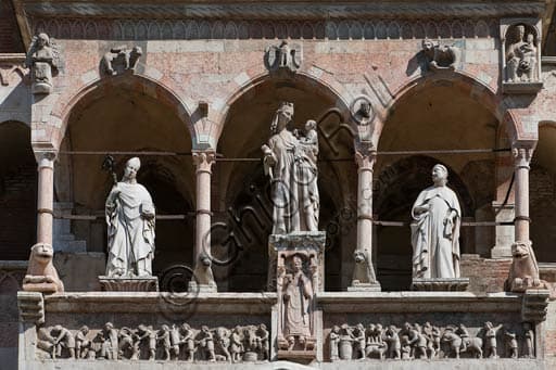 Scultura facciata Duomo Cremona: Madonna con Bambino, santi Omobono e Imerio Vescovo, Loggia del portale maggiore.