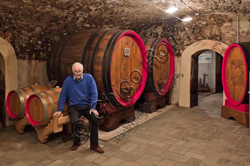 Egidio Tarantola Peloni nelle cantine della distilleria di Bormio accanto ai barili di invecchiamento del Braulio, Italia
