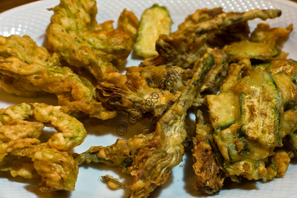Fritto misto di verdure toscano con carciofi e zucchine croccanti, servito in un piatto di ceramica tipica.