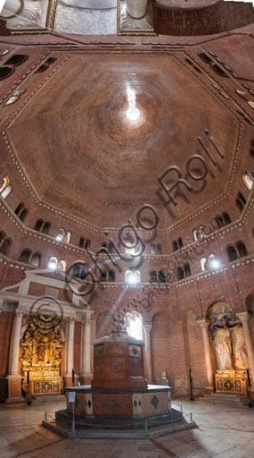 Interno del Battistero di Cremona con pareti in mattoni a vista e fonte battesimale in marmo rosso di Verona