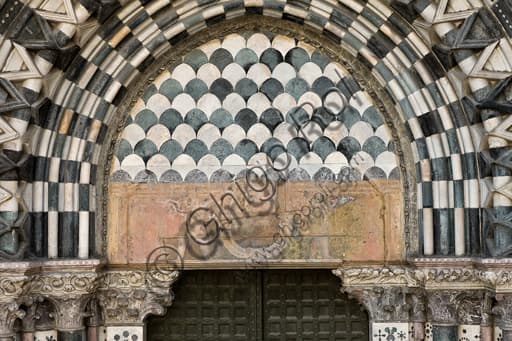 Lunetta e architrave con cartiglio tra angeli reggiclipeo, portale destro facciata ovest Duomo di Genova