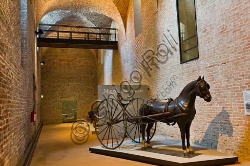 Interno del Museo delle Carrozze di Palazzo Farnese a Piacenza con sulky e statua di cavallo