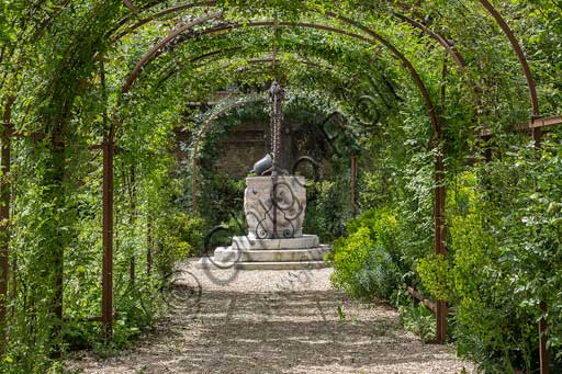 Palazzo Costabili Ferrara, giardino con vera da pozzo in pietra e antica campana in metallo utilizzata come secchio