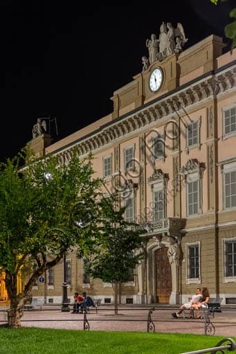 Night view of the monumental façade of the Episcopal Palace in Piacenza, illuminated against the dark sky