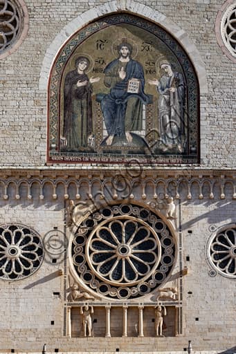 Detail of the upper façade of Spoleto Cathedral showcasing rose windows and a blind gallery with two supporting telamon figures.