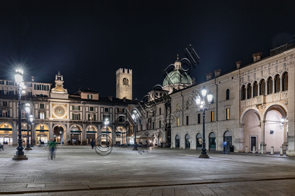 Veduta serale di Piazza della Loggia a Brescia con la Torre dell'Orologio, la Torre del Pégol e il Duomo Nuovo illuminati
