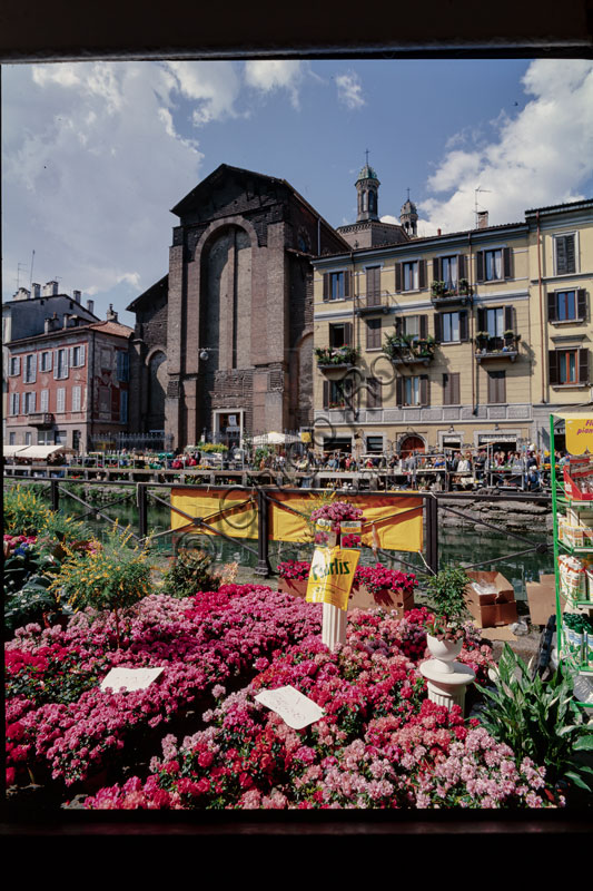 Veduta della Chiesa di Santa Maria delle Grazie lungo il Naviglio a Milano con bancarelle di fiori