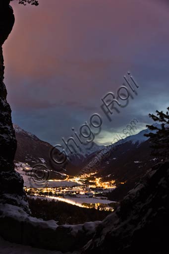 Veduta notturna del comune di Valdisotto illuminato in Alta Valtellina con montagne