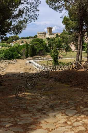 Via lastricata dell'acropoli romana di Populonia con il castello medievale sullo sfondo, Parco Archeologico di Baratti e Populonia, Toscana.