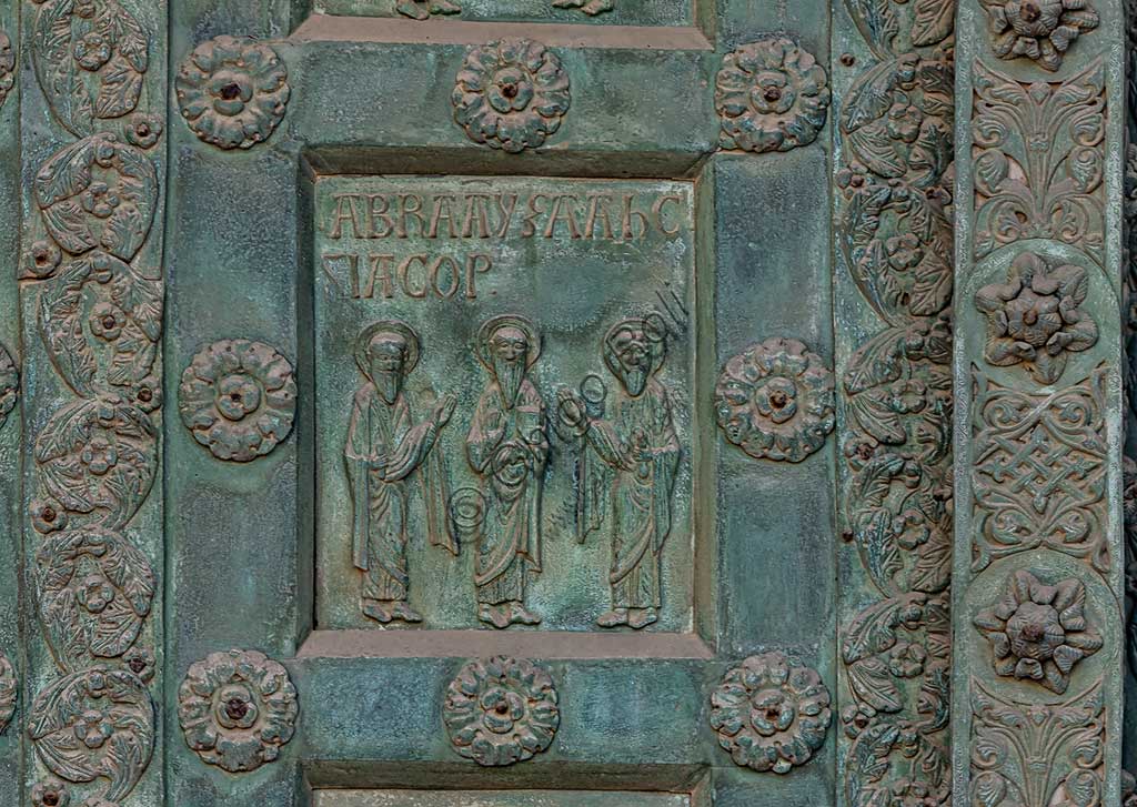 Duomo di Monreale, Porta di Bonanno Pisano (1185-6): formella bronzea con "Abramo, Isacco e Giacobbe" (scena dall'Antico Testamento).La porta è firmata: "Bonanno civis pisanus". Iconograficamente nei cinque ordini inferiori vi sono scene del Vecchio Testamento, sette dedicate alla storia di Adamo ed Eva, e altre sei ad altrettante coppie di profeti mentre nei cinque superiori scene del Nuovo, al sommo Cristo e Maria nella gloria del Paradiso.