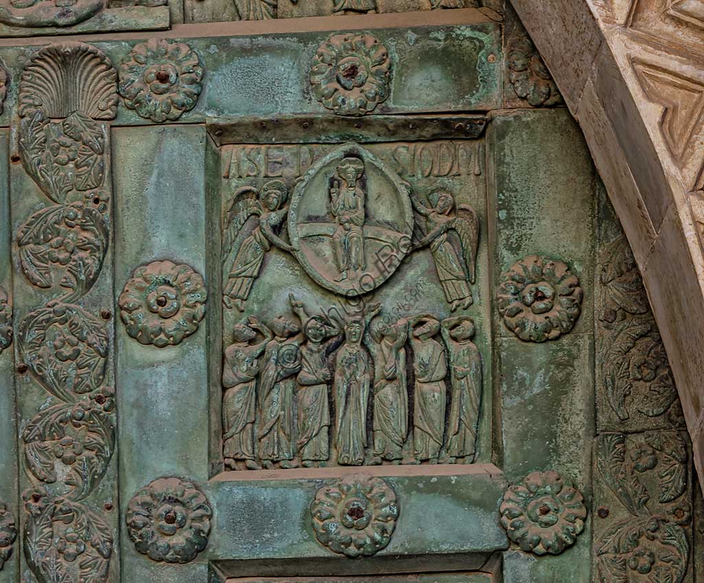 Duomo di Monreale, Porta di Bonanno Pisano (1185-6): formella bronzea con "Ascensione di Cristo" (scena dal Nuovo Testamento).La porta è firmata: "Bonanno civis pisanus". Iconograficamente nei cinque ordini inferiori vi sono scene del Vecchio Testamento, sette dedicate alla storia di Adamo ed Eva, e altre sei ad altrettante coppie di profeti mentre nei cinque superiori scene del Nuovo, al sommo Cristo e Maria nella gloria del Paradiso.