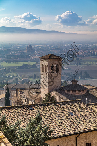 Assisi: veduta di tetti e del campanile dell'Abbazia di San Pietro. Sullo sfondo, nella nebbia, si intravvede la cupola del Santuario della Porziuncola.