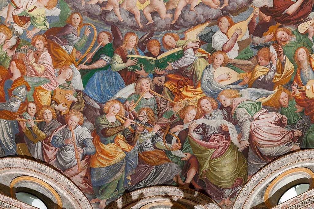   Saronno, Shrine of Our Lady of Miracles: the dome of the transept with the great fresco "Assumption of the Blessed Virgin", known as "The choir of angels playing music" painted by Gaudenzio Ferrari from 1534.Paradise is essentially represented by the multitude of angelic presences, placed to crown the face of God and to welcome the arrival of the Virgin.The angels playing music constitute the most varied orchestra of stringed and percussion instruments that has never been painted.Fifty-six different musical instruments can be identified, the most recognizable ones are ancient instruments, the others have been created by  the artist's imagination. The following instruments are recognized: alpenhorn (horn of the Alps), altobasso, harp, bombard, cimballini or small plates, bagpipes, cornet, flute, pan or syringe flute, hurdy-gurdy, lyre, lute, nyastaranga,ribeca, viella, salterio or zither, tambourine , timpani, triangle, trumpet, viola.Detail.