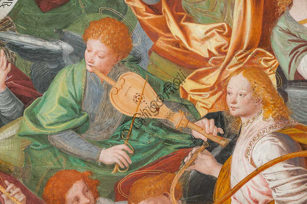 Saronno, Santuario della Beata Vergine dei Miracoli: la cupola del transetto con il grande affresco "Assunzione della Beata Vergine", meglio noto come "Coro di angeli musicanti" vera e propria allegoria del Paradiso, affrescata da Gaudenzio Ferrari a partire dal 1534.A raffigurare il Paradiso è essenzialmente la moltitudine delle presenze angeliche, poste a far da corona al volto di Dio e ad accogliere l'arrivo della Vergine.Gli angeli musicanti  compongono la più variegata orchestra di strumenti a corde ed a fiato ed a percussione che mai sia stata dipinta.Si possono contare ben cinquantasei diversi strumenti musicali, i più riconoscibili come strumenti antichi, altri usciti dalla fantasia dell'artista. Si riconoscono i seguenti strumenti: alpenhorn (corno delle Alpi), altobasso, arpa, bombarda, cimballini o piccoli piatti, cornamusa, cornetto, flauto (dolce e traverso), flauto di Pan o siringa, ghironda, lira, liuto, nyastaranga, organo portativo, ribeca, viella, salterio o cetra, tamburo e tamburello, timpani, triangolo, tromba, viola.Particolare.