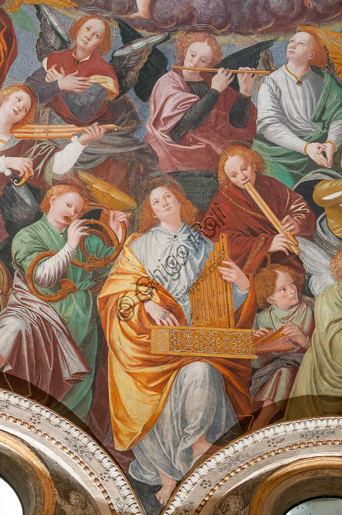 Saronno, Santuario della Beata Vergine dei Miracoli: la cupola del transetto con il grande affresco "Assunzione della Beata Vergine", meglio noto come "Coro di angeli musicanti" vera e propria allegoria del Paradiso, affrescata da Gaudenzio Ferrari a partire dal 1534.A raffigurare il Paradiso è essenzialmente la moltitudine delle presenze angeliche, poste a far da corona al volto di Dio e ad accogliere l'arrivo della Vergine.Gli angeli musicanti  compongono la più variegata orchestra di strumenti a corde ed a fiato ed a percussione che mai sia stata dipinta.Si possono contare ben cinquantasei diversi strumenti musicali, i più riconoscibili come strumenti antichi, altri usciti dalla fantasia dell'artista. Si riconoscono i seguenti strumenti: alpenhorn (corno delle Alpi), altobasso, arpa, bombarda, cimballini o piccoli piatti, cornamusa, cornetto, flauto (dolce e traverso), flauto di Pan o siringa, ghironda, lira, liuto, nyastaranga, organo portativo, ribeca, viella, salterio o cetra, tamburo e tamburello, timpani, triangolo, tromba, viola.Particolare.