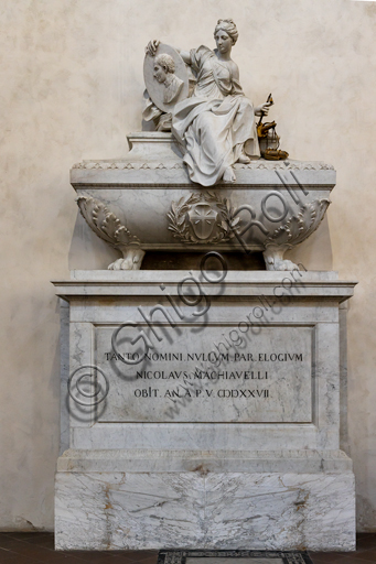 Basilica of the Holy Cross: "Monument to Niccolò Machiavelli: Philosopher, Historian, Politician", by Innocenzo Spinazzi, 1787, marble and bronze.Above the sarcophagus  there is a statue that represents a female figure which is the allegory of politics. In her right hand she holds a medallion with the portrait of Machiavelli, in the left she holds the symbols of Politics, History and Poetry. On the sarcophagus there is the family coat of arms, and on the base a Latin epigraph whose translation i is "To such a great name, no epitaph is adequate"