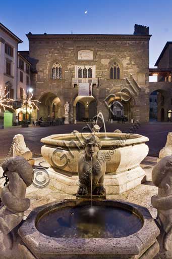 Bergamo, Città alta, Piazza Vecchia: night view of  the fountain given by the podesta Alvise II Contarini in 1780, and, in the background, Palazzo della Ragione (Ragione Palace).