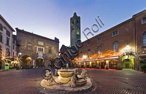 Bergamo, Città alta, Piazza Vecchia: night view of  the fountain given by the podesta Alvise II Contarini in 1780, and, in the background, Palazzo della Ragione (Ragione Palace) and the Civic Tower, known as the Campanone.