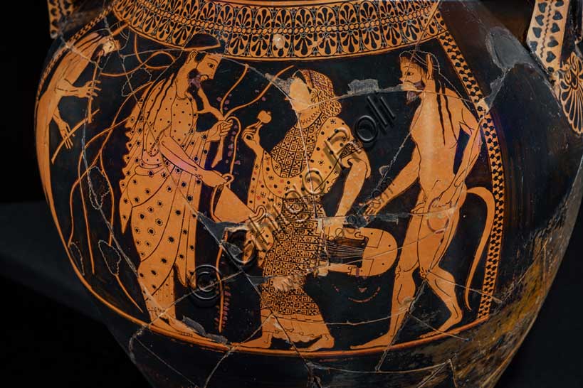 Museo Civico Archeologico di Bologna:Anfora attica bilingue del Pittore di Andokides, dal sepolcreto Arnoaldi, tomba 85.Intorno al 530 a.C., il pittore Andokide, che lavorava nello studio ateniese del ceramista Exechia, iniziò a sperimentare una nuova tecnica decorativa in terracotta in cui le figure venivano delineate lasciandone l'interno non dipinto, anziché dipingerle di nero. In questo modo realizzò diverse opere "bilingue", in cui le scene erano realizzate con le figure nere su un lato e le figure rosse, di nuova invenzione, sull'altro.Questa anfora, attribuibile allo stesso Andokide, è l'unico esemplare finora rinvenuto nell'Etruria padana che testimonia questo tipo di produzione. A differenza di altre anfore con la stessa scena nelle due tecniche sui due lati, qui gli episodi raffigurati sono diversi: da un lato è raffigurato Eracle, che uccide il leone nemeo, assistito da Iolao e al cospetto di Atena; dall'altro, Dioniso a banchetto, con al fianco Arianna che suona la cetra, e due satiri. L'anfora è un pezzo importato di pregio ed era l'unico elemento del corredo funerario di una tomba a incinerazione, nella quale i resti ossei erano stranamente depositati in un angolo della trincea, all'esterno dell'urna.È la più antica attestazione a Felsina della figura di Eracle.Inv. 18017.Particolare.