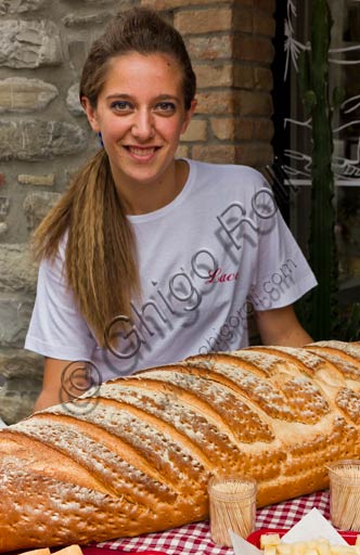Bobbio: ragazza con il tipico pane di Bobbio.