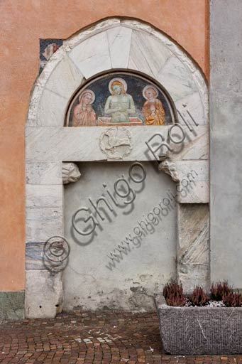 Bormio, Collegiata dei Santi Gervasio e Protasio (patroni di Bormio), facciata: portale laterale con lunetta affrescata (XV sec.).