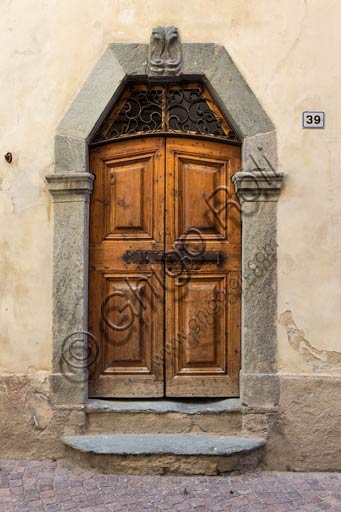 Bormio: porta in legno di antica casa con stipite in pietra.