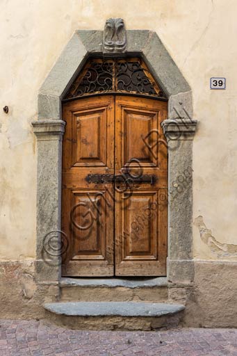  Bormio: old house wooden door with stone jamb.