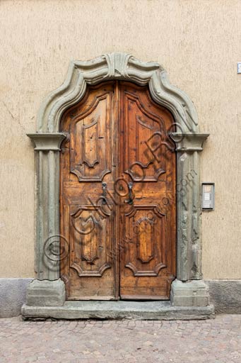 Bormio: porta in legno di antica casa con stipite in pietra.