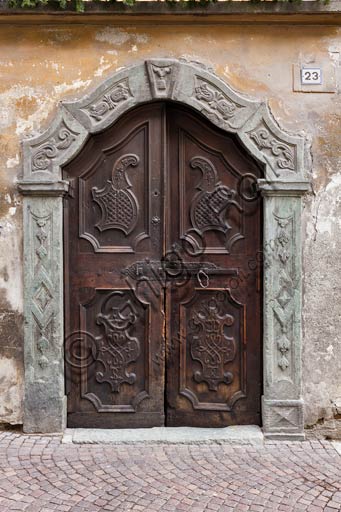 Bormio: porta in legno di antica casa con stipite in pietra.