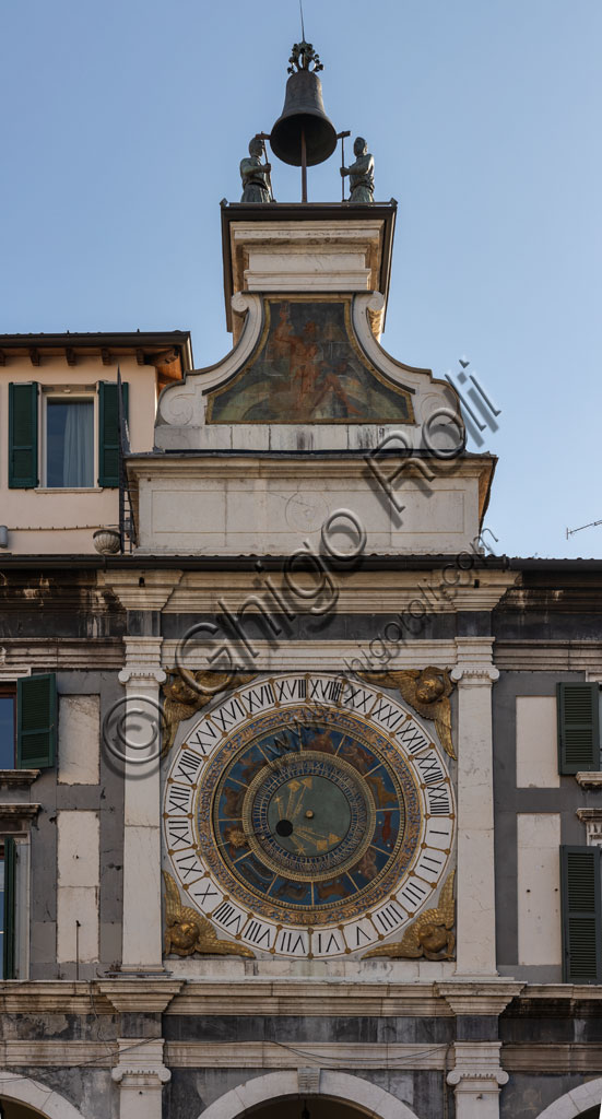 Brescia, piazza della Loggia (a Renaissance square where the Venetian influence is evident): the Clock Tower (1540 - 1550) with the astronomical quadrant with concentric rings, decorated in gold and blue and with symbols of the Zodiacal signs. Above the dial, a plinth adorned with the symbol of the sun and a volute base that stand as a pedestal for the automata, the popular Macc de le ure (crazy hours) that hammer at every hour on the bell.