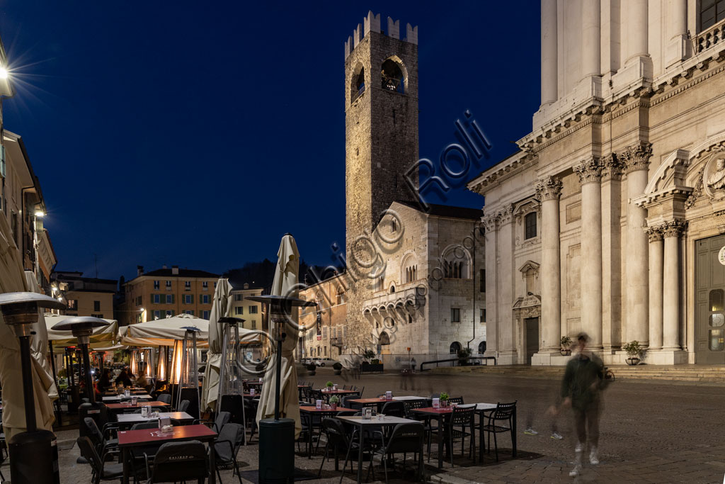 Brescia, piazza Paolo VI: veduta serale. Da sinistra, il Broletto, con la torre del Pégol e la Loggia delle grida; e parte della facciata del Duomo Nuovo (Cattedrale estiva di S. Maria Assunta), in stile tardo barocco dall'imponente facciata in marmo di Botticino.