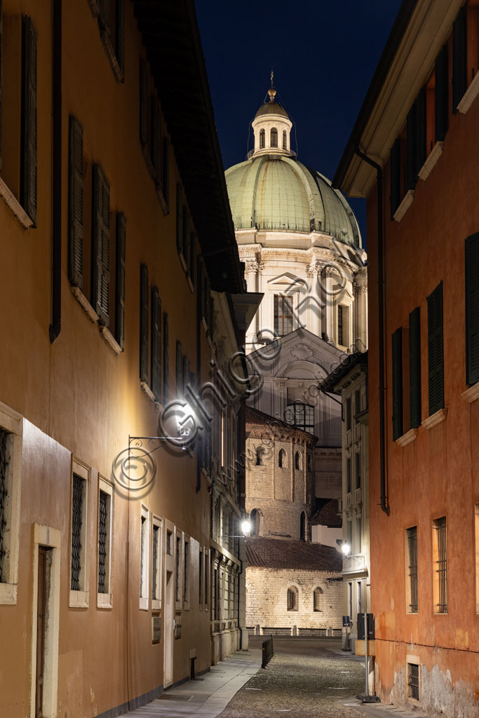 Brescia: veduta serale delle cattedrali. Sullo sfondo, il Duomo Nuovo (Cattedrale estiva di S. Maria Assunta), in stile tardo barocco dall'imponente facciata e cupola in marmo di Botticino. In primo piano, il Duomo Vecchio (cattedrale invernale di S. Maria Assunta).