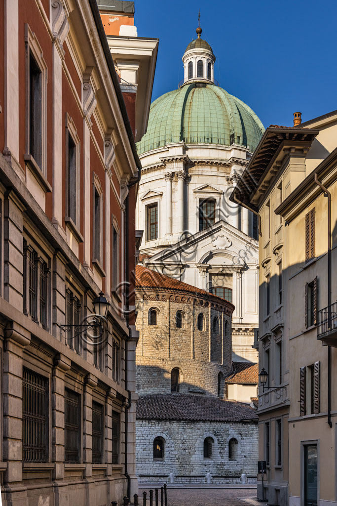 Brescia: vicolo del centro storico. Sullo sfondo,  la cupola del Duomo Nuovo (Cattedrale estiva di S. Maria Assunta), in stile tardo barocco dall'imponente facciata in marmo di Botticino e la struttura cilindrica del Duomo Vecchio (Cattedrale invernale di S. Maria Assunta), costruito alla fine dell'XI secolo.