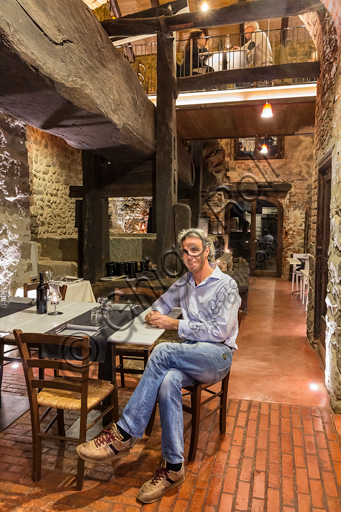 Candelo, Ricetto (fortified structure) Restaurant Il Torchio 1763:  the room with the ancient winepress and the owner Alberto Barbirato.
